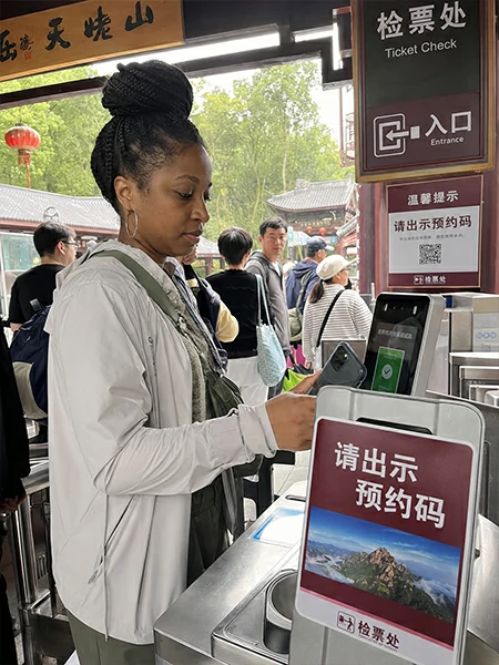 Traveler checking attraction tickets QR code entry and booking details during a China trip