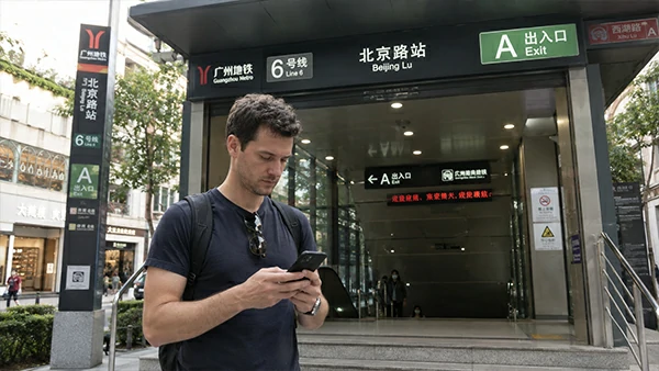 Foreign traveler checking a map near a numbered metro exit in China