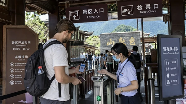 Foreign visitor presenting a passport for real-name entry verification at a China attraction